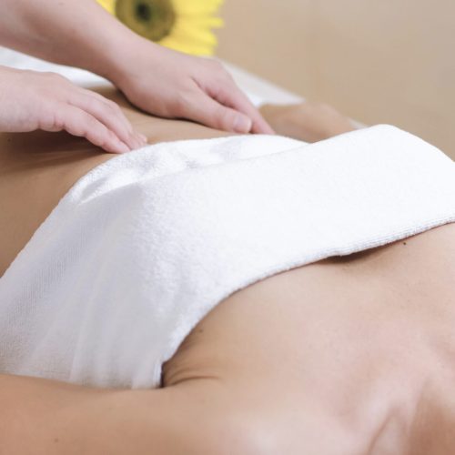 Young woman having abdomen massage. Masseur make massage for stomach